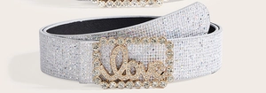 Dettaglio cintura argento glitter con fibbia dorata con scritta LOVE e strass