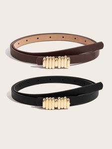 Detail of slim PU leather belts with textured gold buckles in black and brown