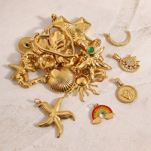 Macro shot of 18k gold stainless steel charms including sun, starfish and shells