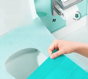 Detail of disposable toilet seat cover with four adhesive points for anti-slip fixation