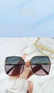 Detail of stylish sunglasses showing gradient lenses and golden H metal hinge decor