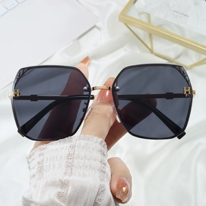 Fashionable black oversized sunglasses with gold H-logo hardware and gradient grey lenses