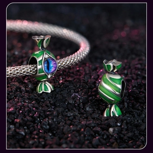 Macro shot of Halloween candy charm with green enamel and vibrant purple gemstone