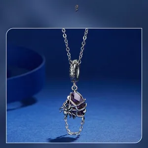 Macro view of purple crystal spider pendant with silver web on a dark blue background