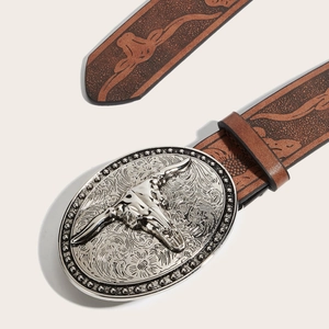 Western cowboy belt featuring embossed leather strap and vintage bull skull buckle