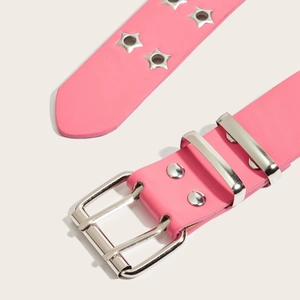 Détail de la ceinture punk rose avec œillets argentés en étoile et boucle métal