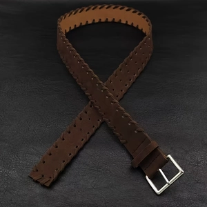 Detail of dark brown leather belt with woven edges, silver buckle and vintage punch holes