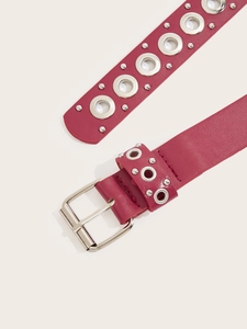 Dettaglio cintura punk rosa acceso con occhielli in metallo e fibbia lucida quadrata