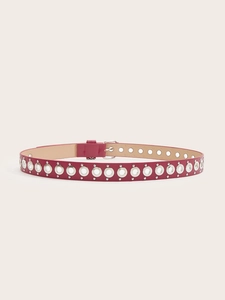 Dettaglio della cintura punk rosa in pelle con doppia fila di occhielli in metallo argento
