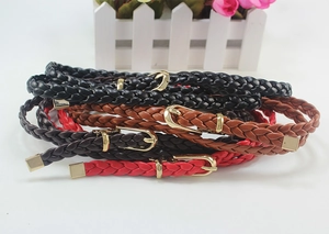 Close-up of multicolored braided PU leather belts with gold D-ring metal buckles