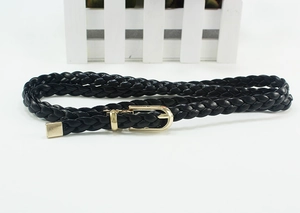 Detail of black woven leather belt featuring a sleek gold metal buckle and tip finish