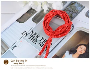 Detail showing the red hand-woven waist rope belt with fringes and flexible texture