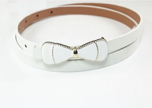 Close-up of white skinny belt with a gold bow buckle and smooth patent leather finish