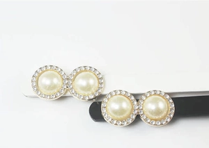 Detail view of double faux pearl decorative buckle with sparkling rhinestones on gold base