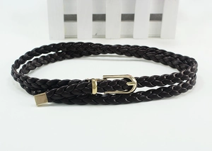 Close-up of dark brown woven belt with elegant round gold metal buckle on white base