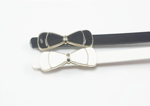 Detail of sweet bow buckle skinny belts in black and white leather for women