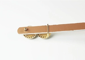 Detailed macro view of the gold metal buckle back with gear texture and mounting structure