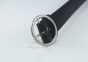 Close-up of a slim black leather belt with a polished silver-tone circular metal buckle