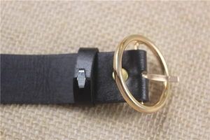 Casual black leather women belt featuring a polished gold round buckle on linen background