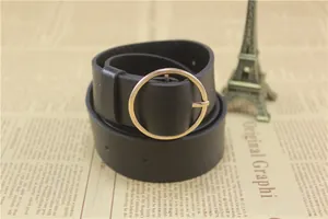 Detail of black matte leather belt with polished gold round buckle on vintage background