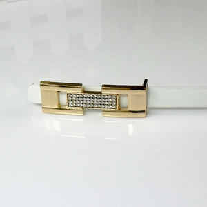 Fine ceinture en cuir verni blanc avec boucle dorée ornée de strass pour femme