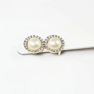 Elegant gold earrings with cream pearls and sparkling rhinestone halo on white stand