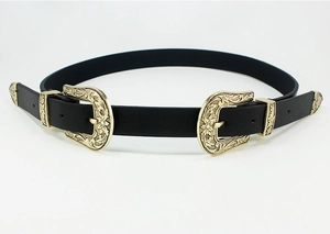 Close-up of dual vintage metal buckles with floral carvings on black leather belt