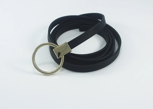 Détail d'une fine ceinture noire pour femmes avec une boucle ronde dorée minimaliste