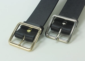 Close-up of black leather belts with gold and silver square metal buckles and fine texture