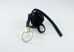 Détail de ceinture en cuir noir avec une grande boucle ronde en métal doré