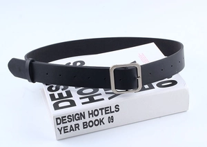 Detail of minimalist black leather belt featuring a polished silver square pin buckle