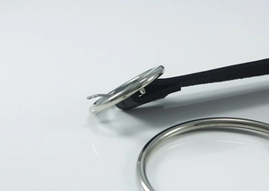 Detailed macro view of black leather belt with polished silver round metal buckle and pin