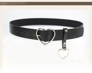 Detail of black slim belt with silver heart-shaped buckle and matching heart pendant