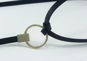 Vue macro détaillée de la boucle en métal doré poli sur une fine ceinture en cuir noir