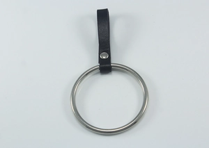 Detail of silver metal ring with black leather strap and rivet for jeans belts
