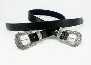 Detail of vintage double-buckle leather belt with silver floral western carvings