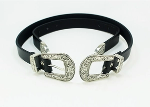 Detail of western vintage belt showing silver engraved double buckles and black leather