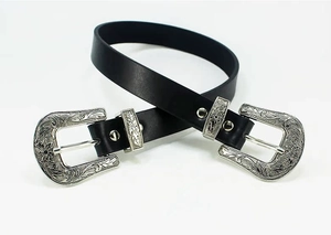 Detailed view of vintage black leather belt featuring dual silver engraved buckles