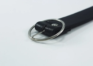 Detailed macro shot of a black leather belt featuring a polished silver metal round buckle