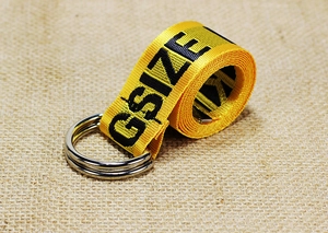 Detail of yellow nylon belt featuring a double D-ring buckle and GSIZE print