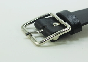 Detail of minimalist black leather belt featuring a polished silver square buckle and stitching