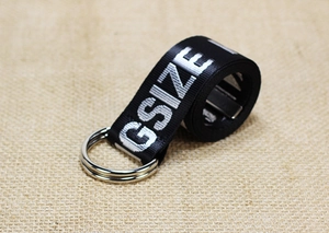 Detail of black nylon canvas belt featuring double D-ring buckle and GSIZE print