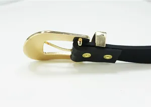 Close-up of solid gold metal horseshoe buckle and black leather belt strap detail