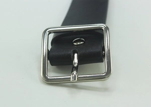 Close-up of black leather belt with silver square metal buckle and smooth texture detail