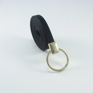 Ceinture fine en similicuir noir avec une boucle dorée ronde élégante sur un fond blanc épuré
