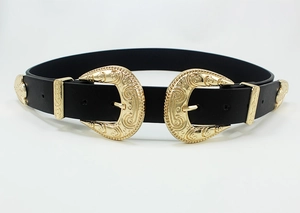 Detailed view of dual golden floral engraved buckles on a black vintage western style belt