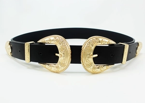 Close-up of vintage Western belt with dual gold engraved buckles and scroll carvings