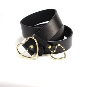 Women's black leather belt featuring a golden heart buckle and matching heart pendant charm