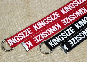Detalle de cinturones de lona rojos y negros con hebillas de anillo en D y letras