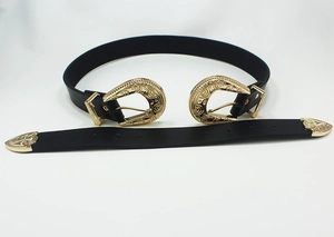 Detailed view of vintage western carved gold double buckles on a black leather belt
